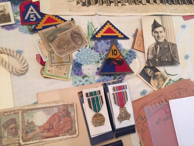 Photograph of a veteran's memorabilia, including photo, medals, foreign currency, patches and insignia.
